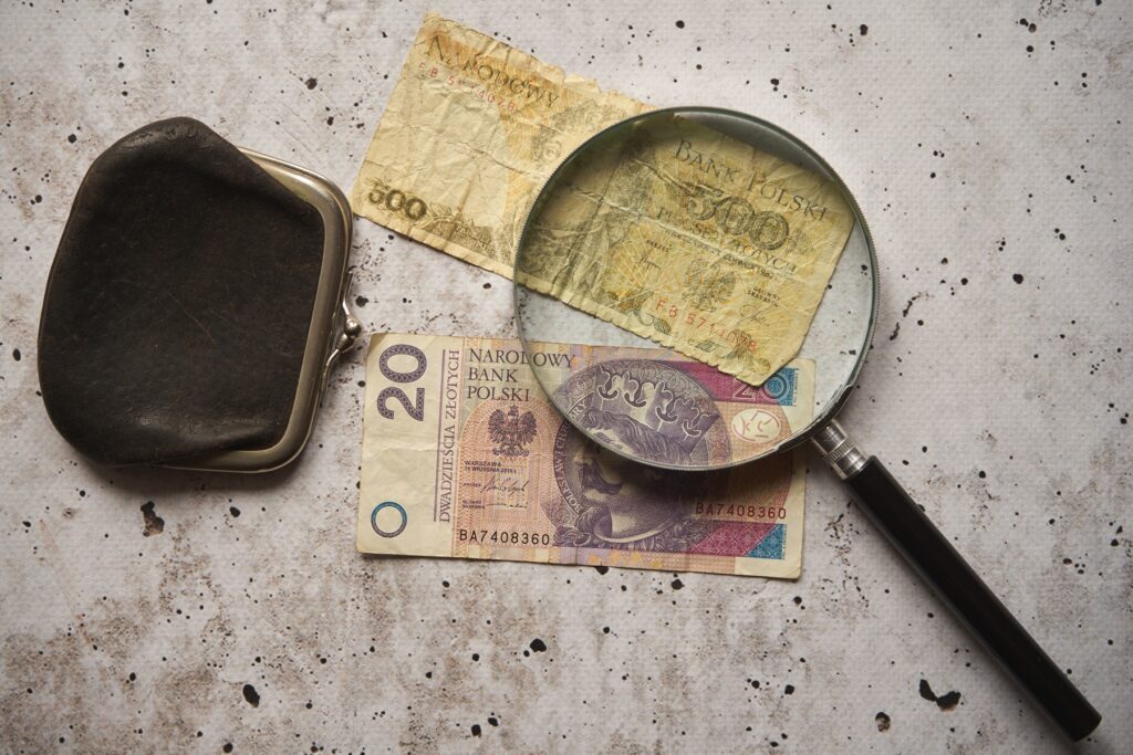 Porównanie banknotu 10 000 starych złotych i monety 1 nowy złoty, ilustrujące proces denominacji złotego i odcięcie czterech zer